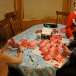 Kids and Mom weaving Valentine hearts for classmates